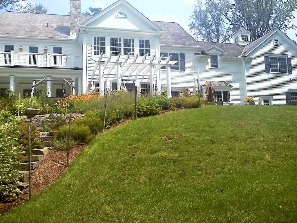 A large white house with a lush green lawn in front of it