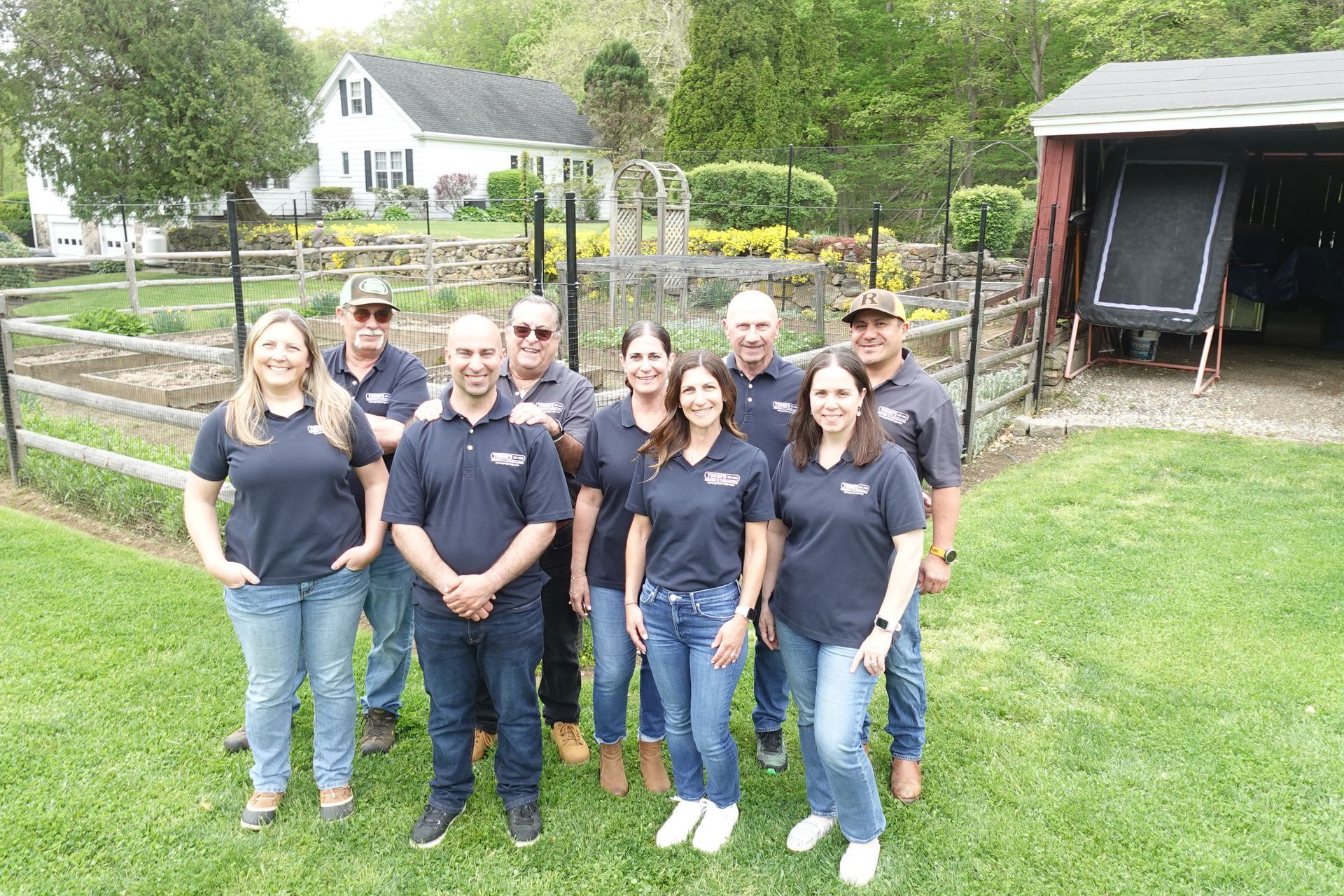 A group of people are posing for a picture in front of a barn