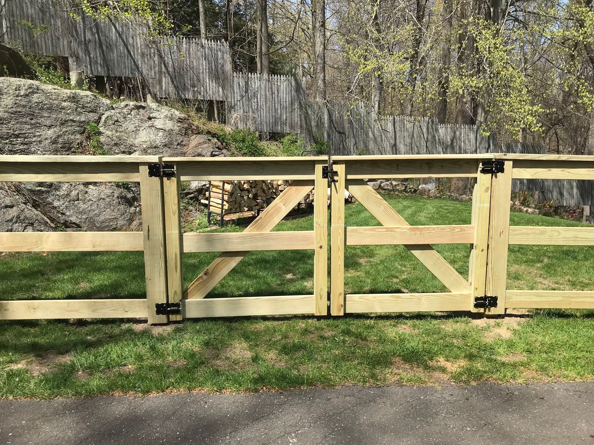 A wooden fence is sitting on top of a lush green field.