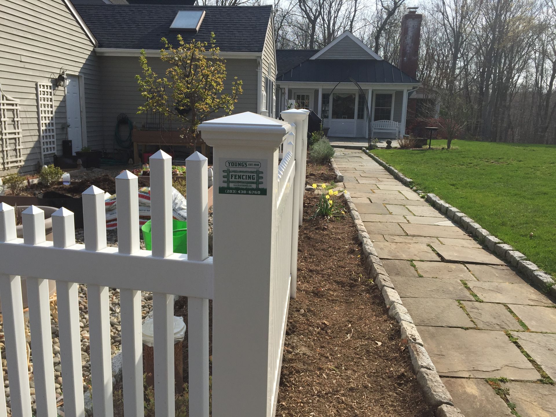 A white picket fence in front of a house