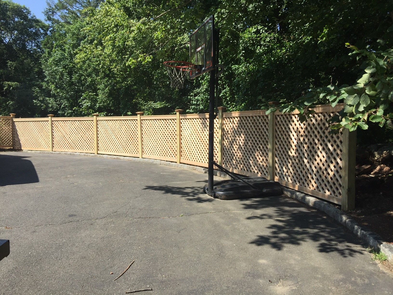 A wooden fence with a basketball hoop in the background