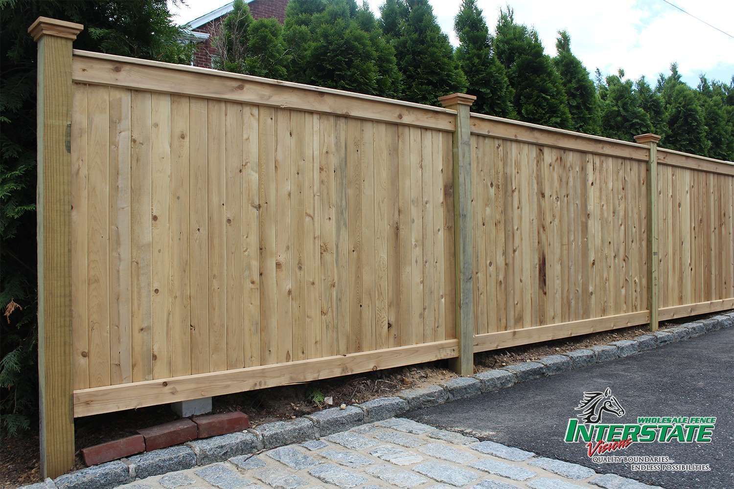A wooden fence is sitting on the side of a road.