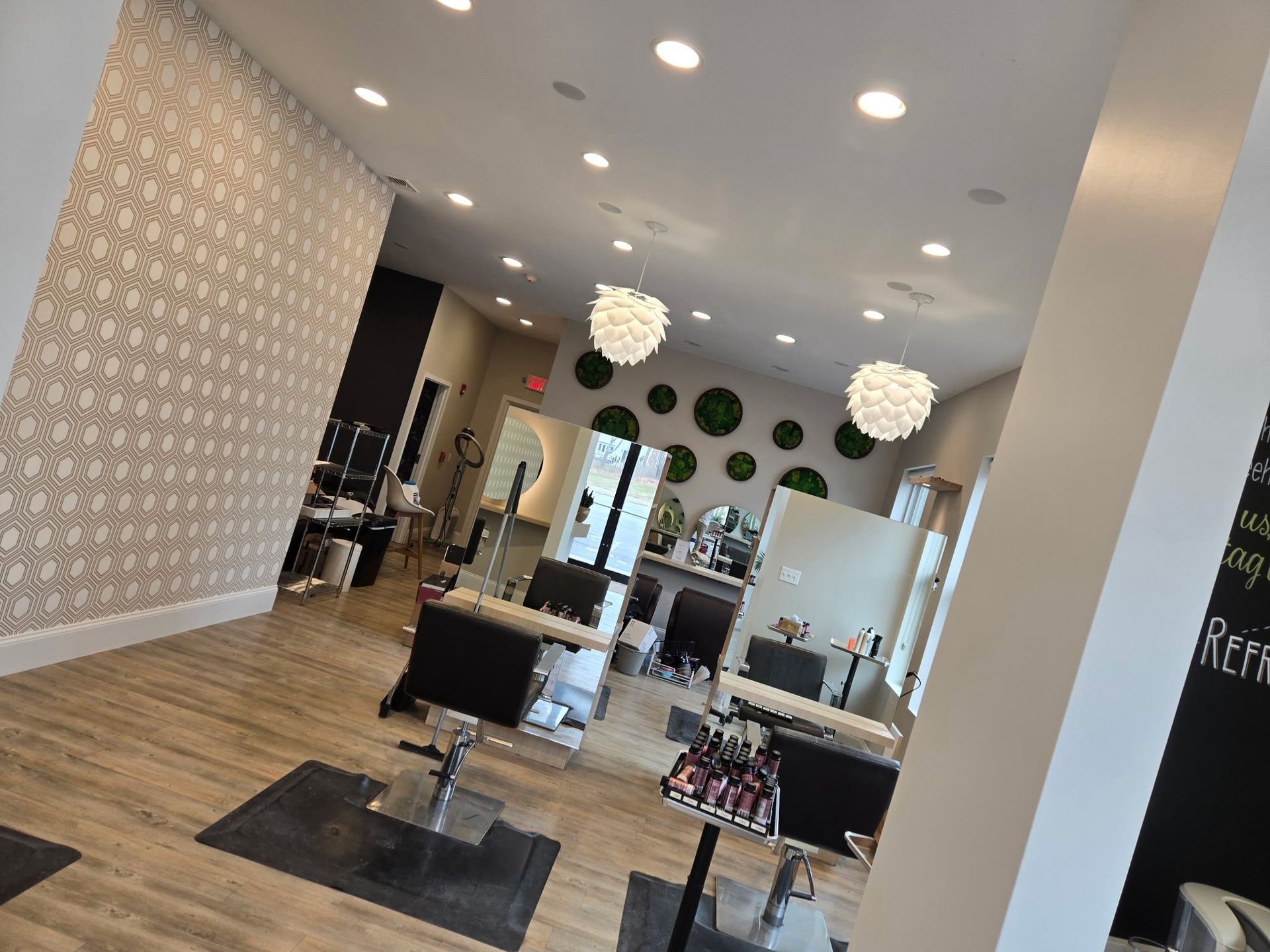 Empty modern hair salon with styling chairs, mirrors, and black-and-white decor.