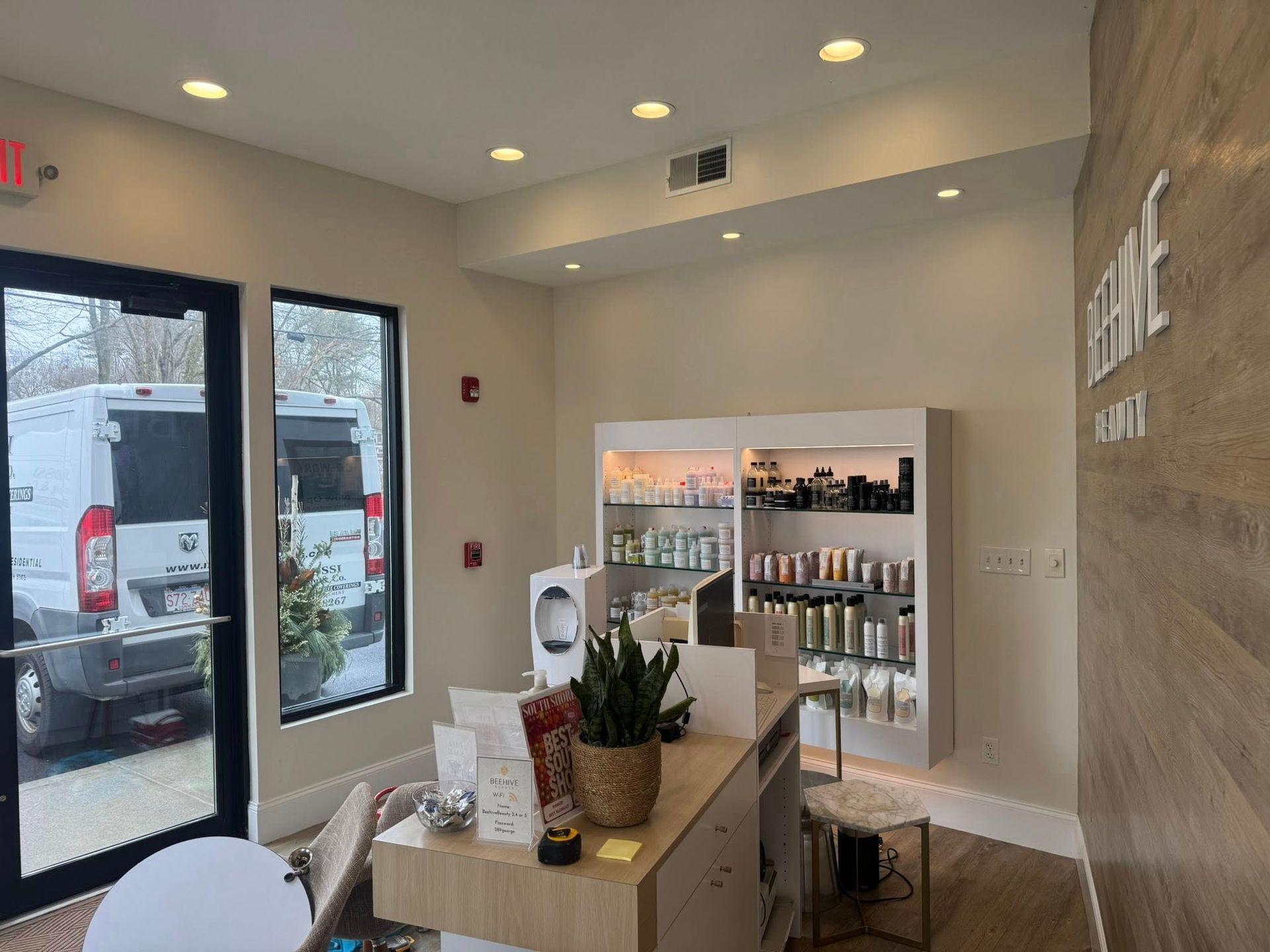 Modern minimalist retail shop interior with display shelves, counter, and large front windows