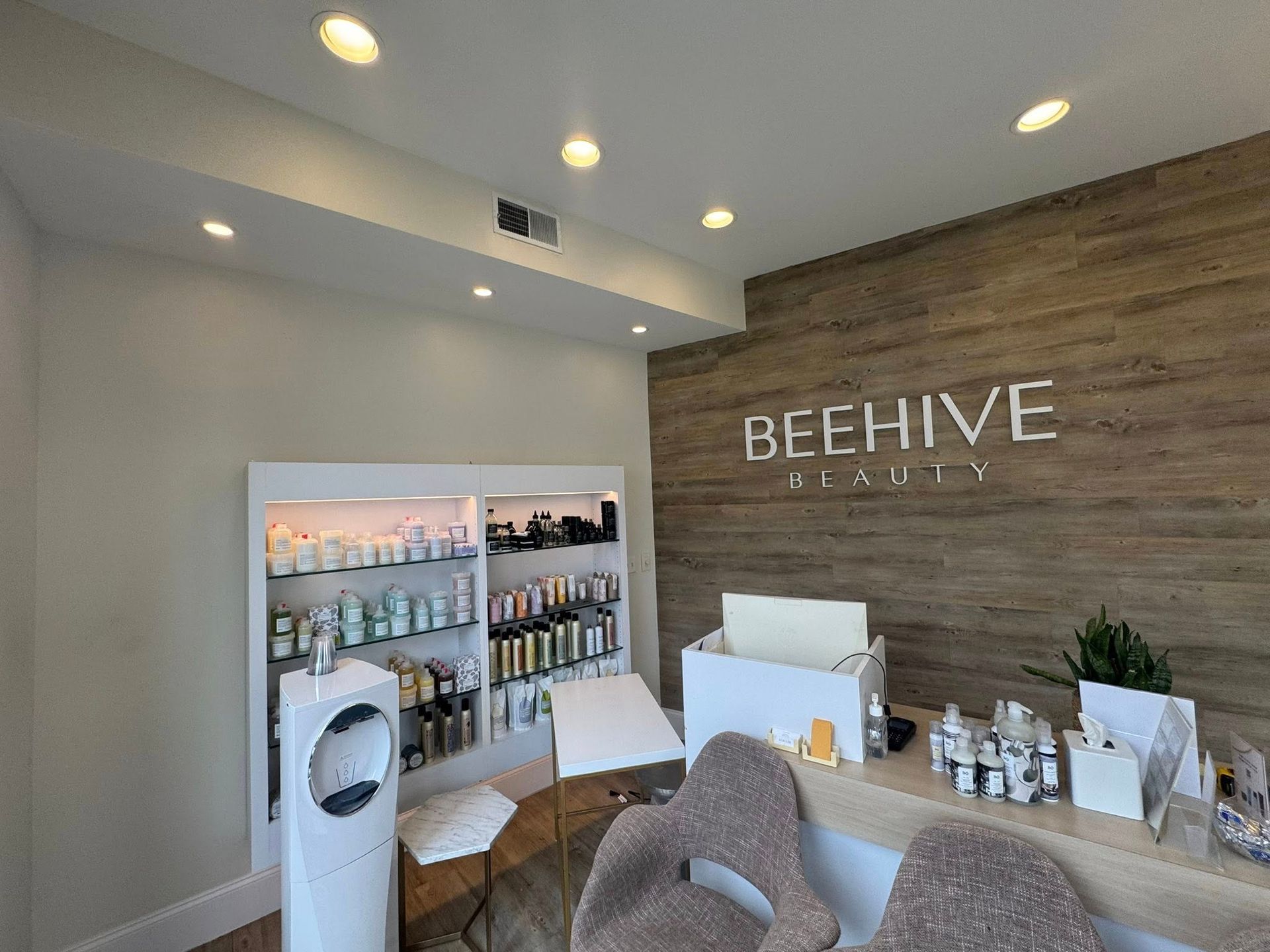 Beehive storefront interior with product display shelves and wooden accent wall sign