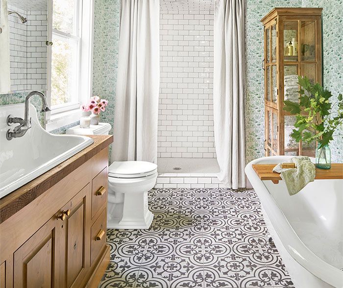 Bathroom with patterned floor, wood vanity, white fixtures, and a glass-enclosed shower.