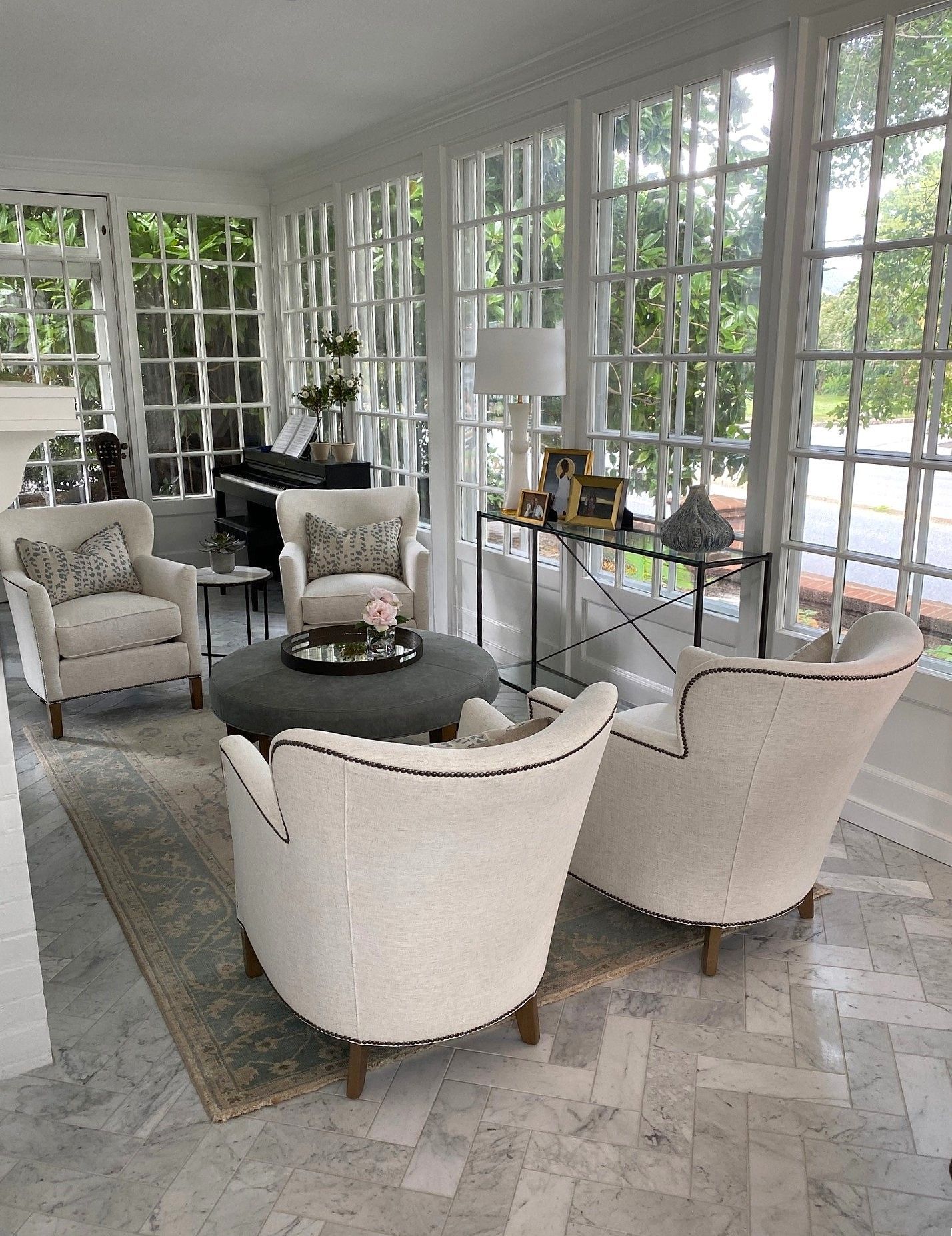 A living room with a lot of windows and chairs
