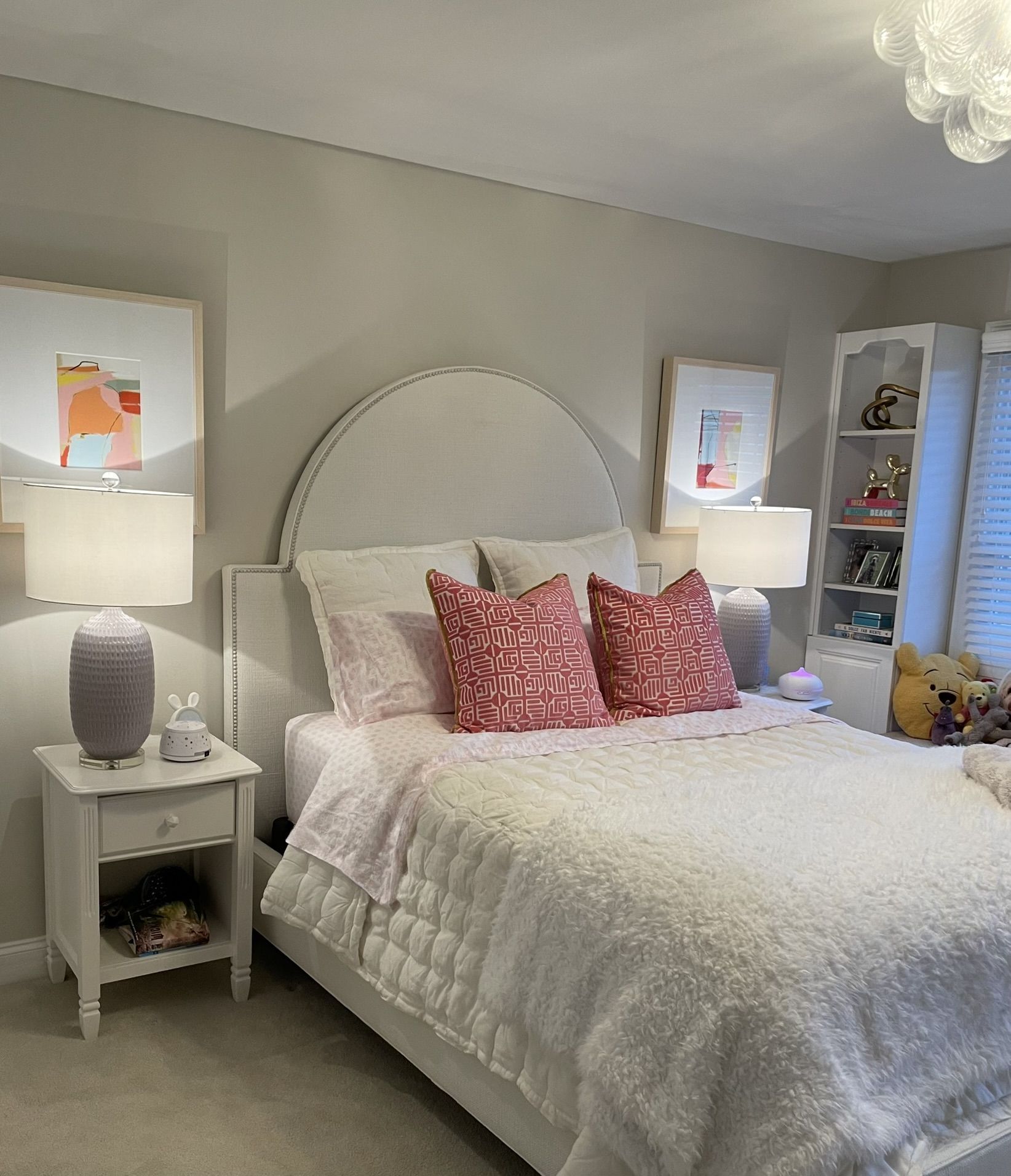 A bedroom with a bed , nightstand and lamps