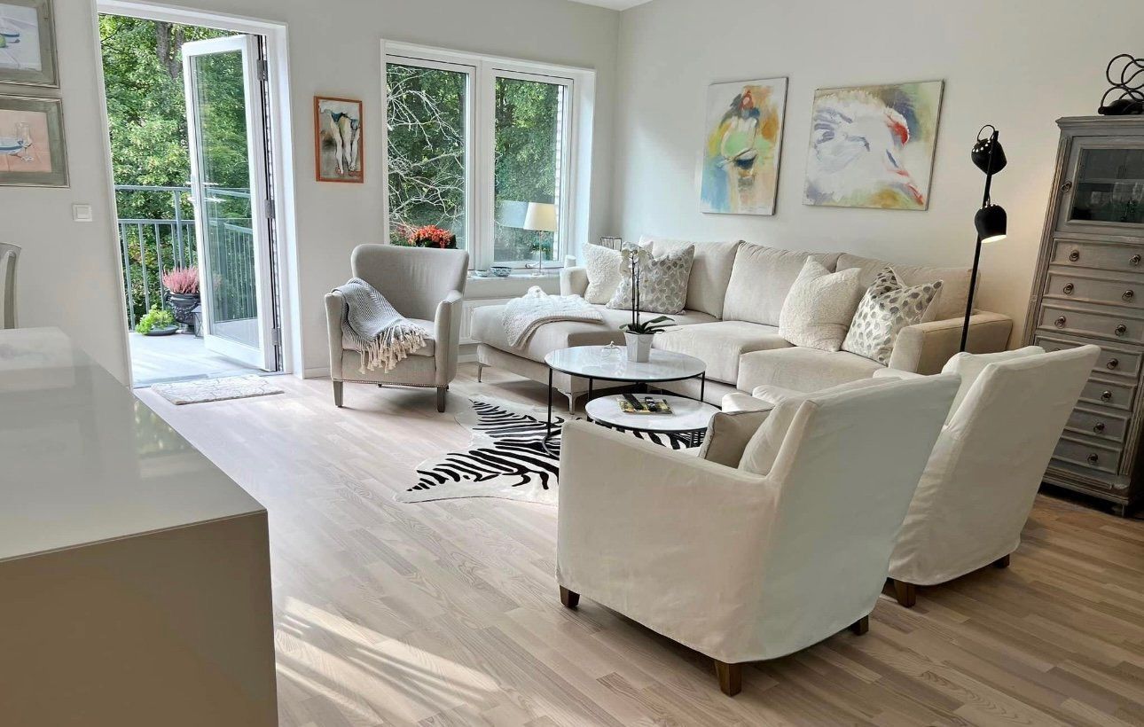 A living room with a couch, chairs, and a table.