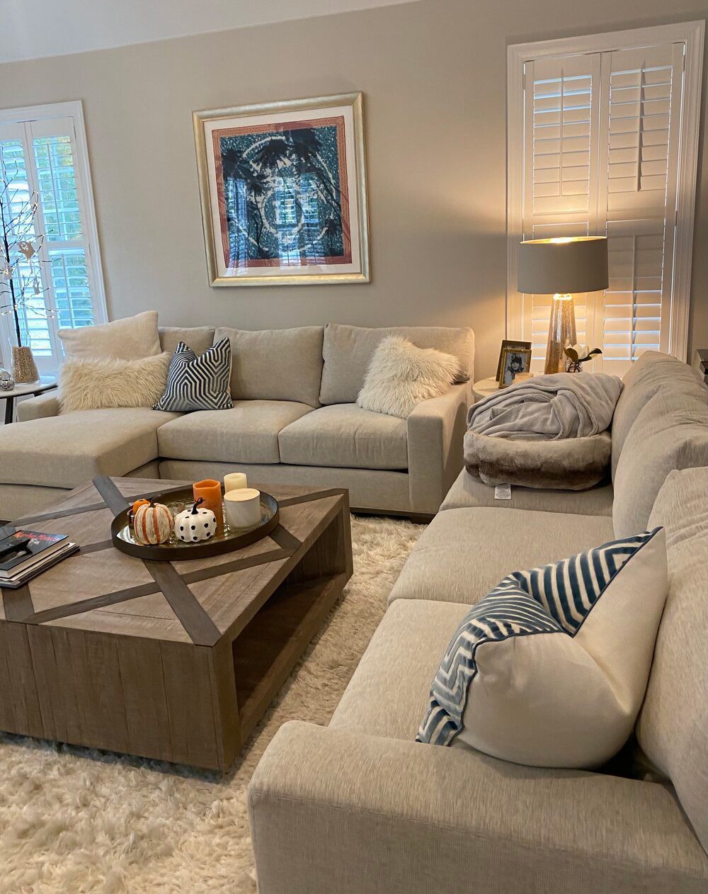 A living room with two couches, a coffee table, and a painting on the wall.