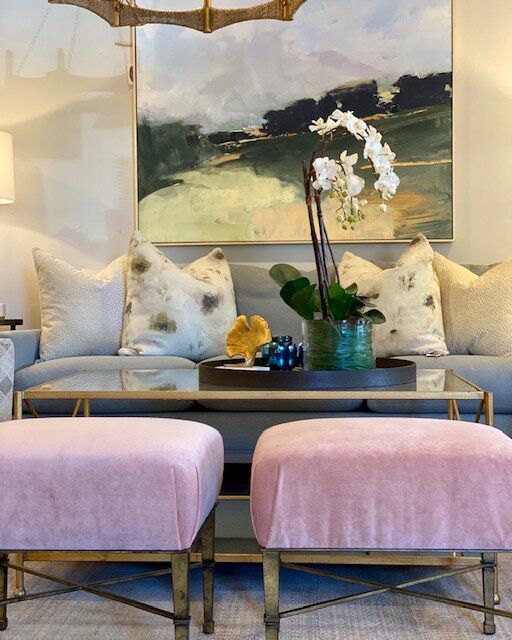A living room with a couch and two pink ottomans