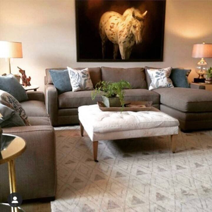 A living room with a painting of a bull on the wall above the couch