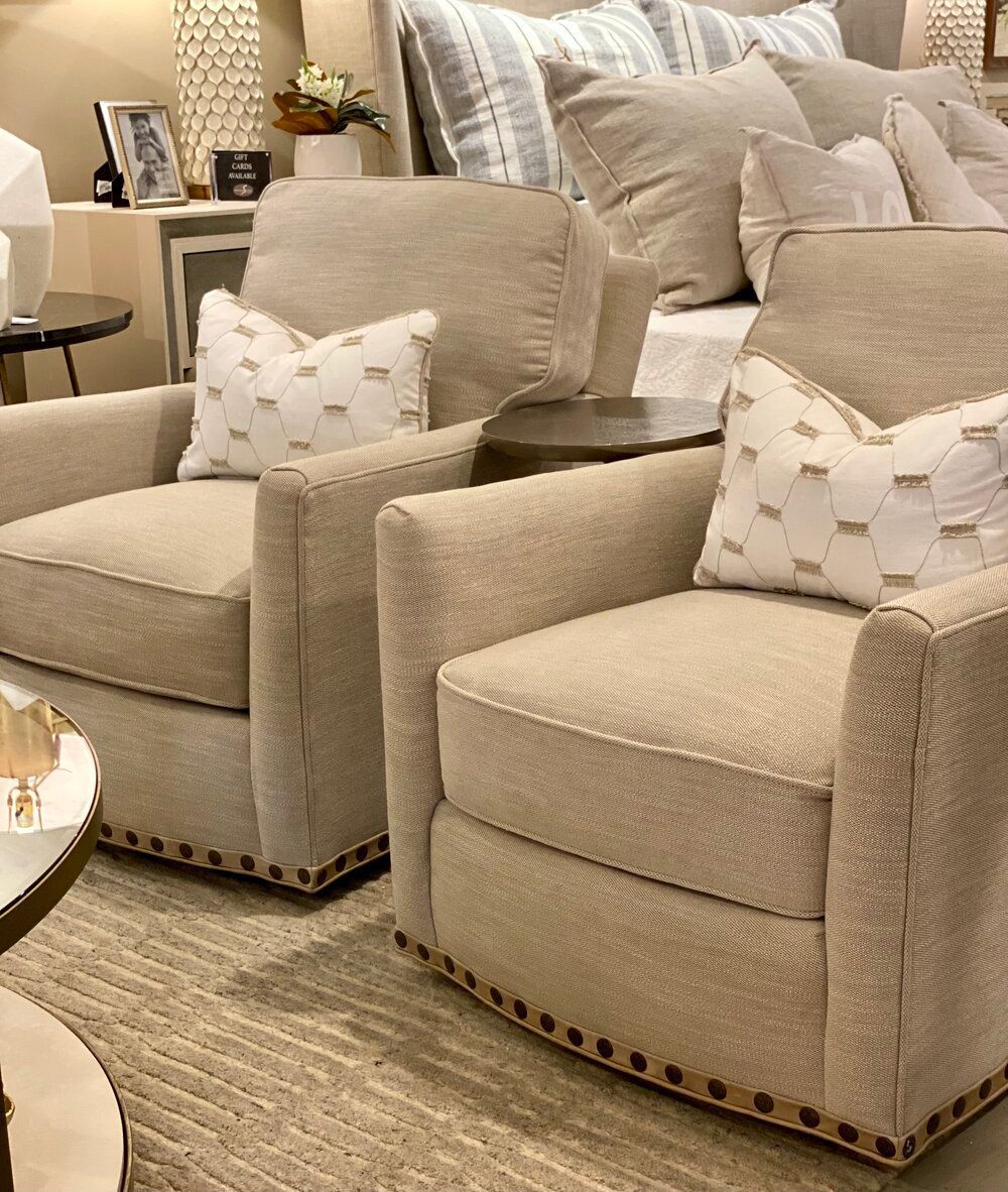 Two chairs are sitting in a living room next to a bed.