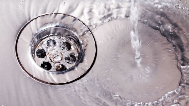 Chrome sink drain with swirling water and bubbles