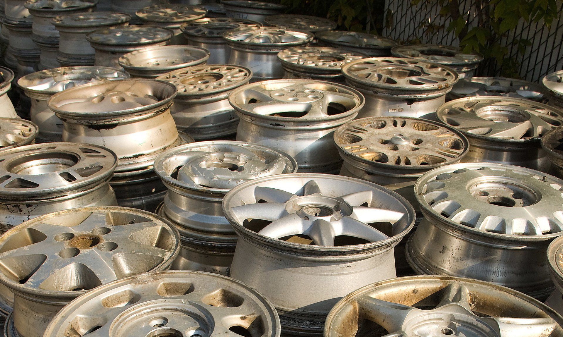 Pile of weathered car rims in various designs.