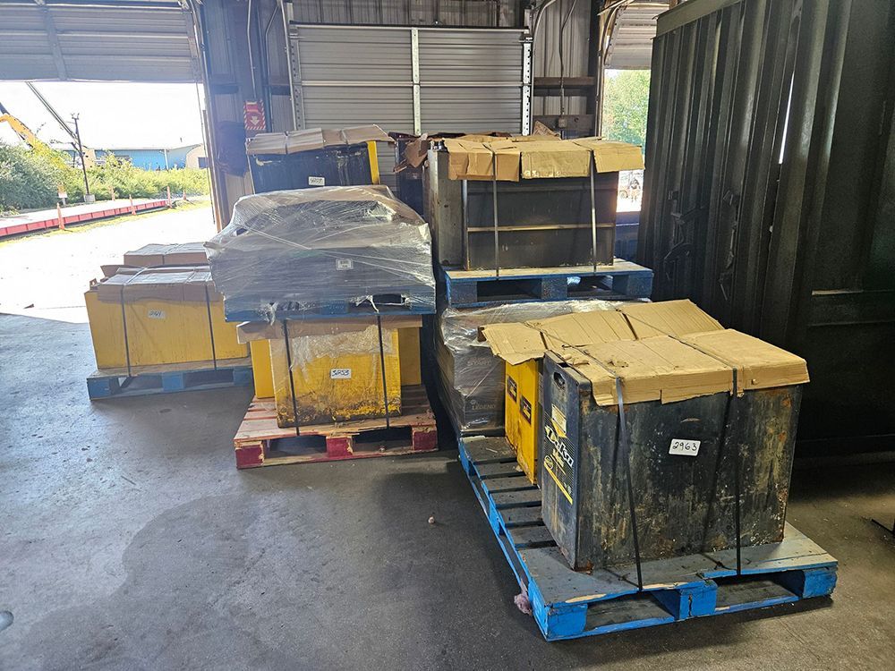 Several stacked yellow boxes on pallets inside a warehouse.