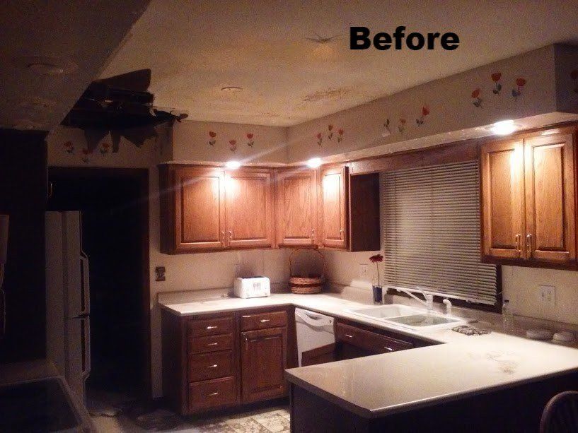 Dark kitchen with wooden cabinets, countertops, and a hole in the ceiling labeled