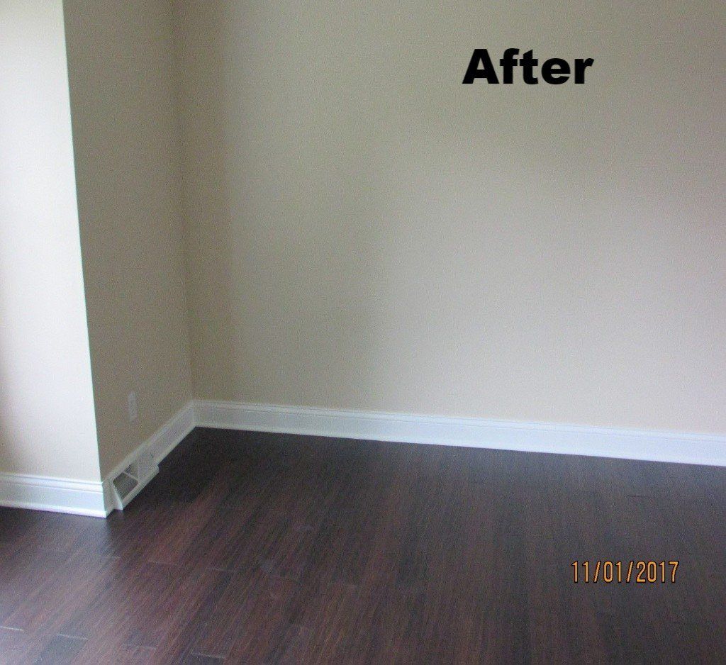 An empty room with dark wood floors and beige walls labeled