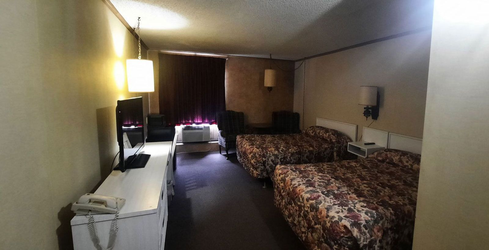 Motel room with two double beds and flat-screen television