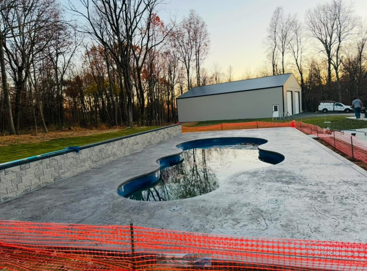 A swimming pool is being built in the backyard of a house.