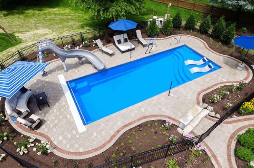 An aerial view of a large swimming pool with a slide and chairs.