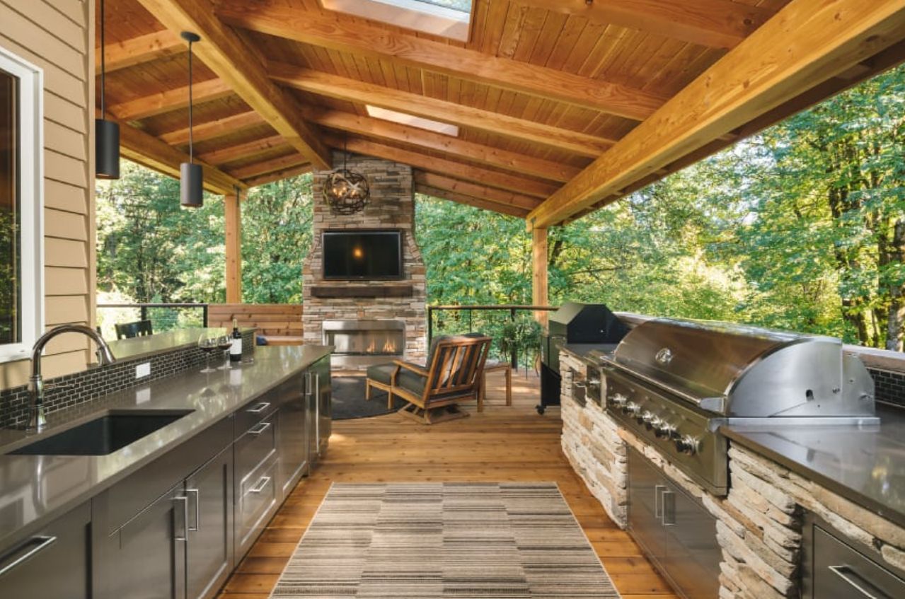 A large outdoor kitchen with stainless steel cabinets and a grill.