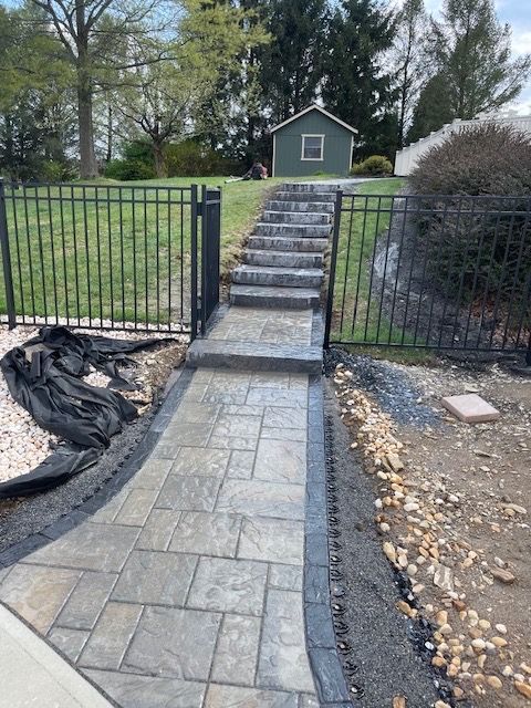 A walkway with stairs leading up to a green shed