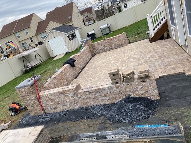 A patio is being built in the backyard of a house.