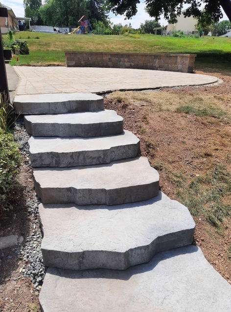 A set of concrete steps leading up to a grassy area