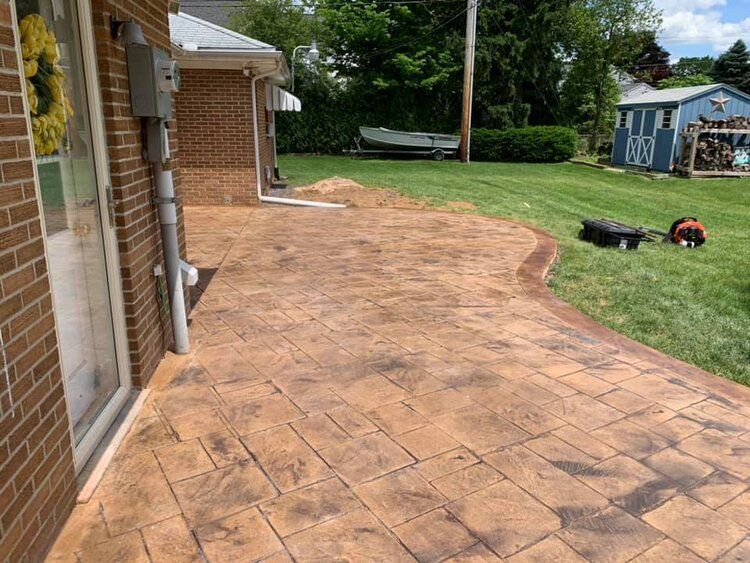 A brick house with a concrete patio in front of it.