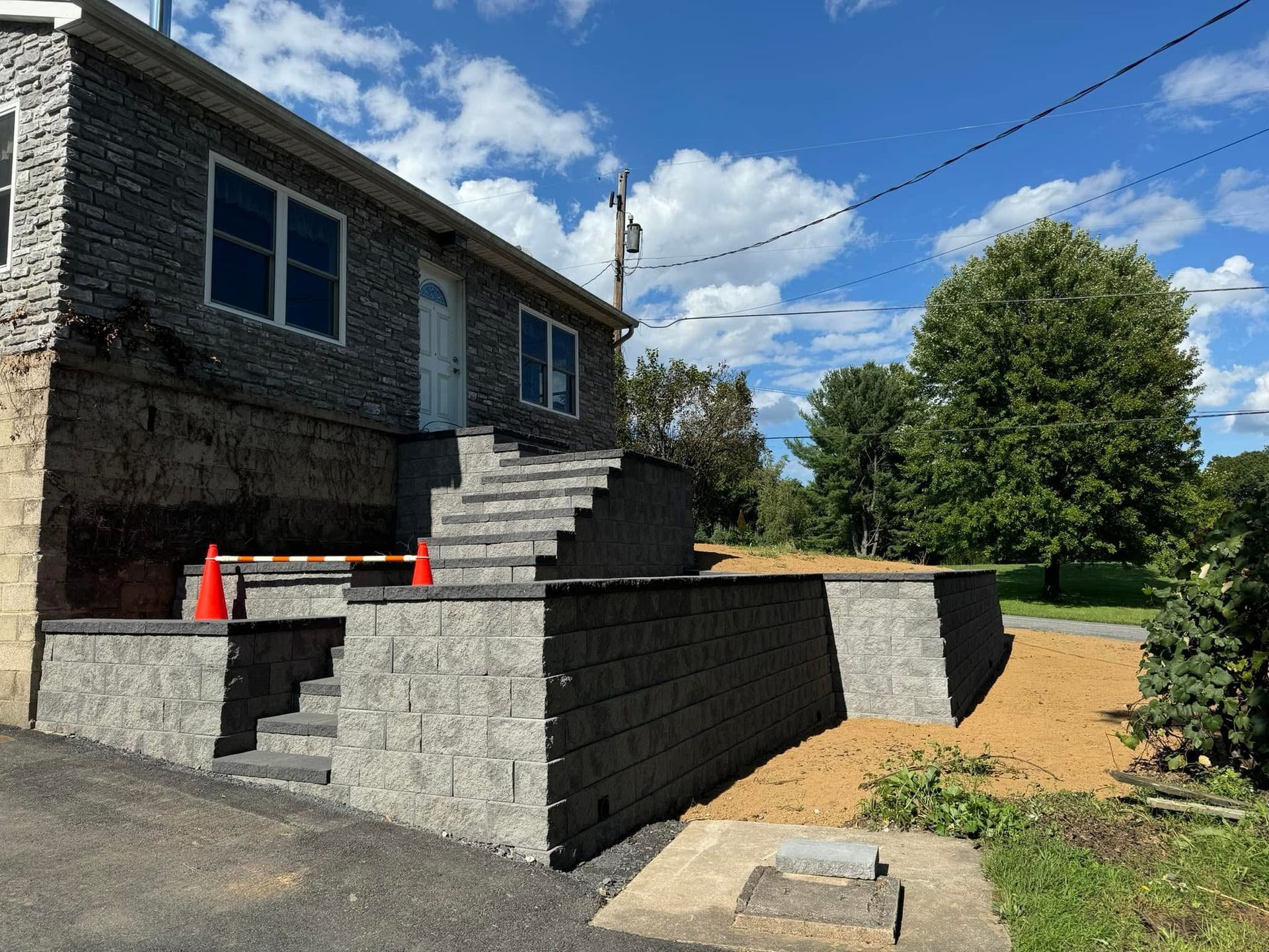 A stone house with stairs leading up to the front door.