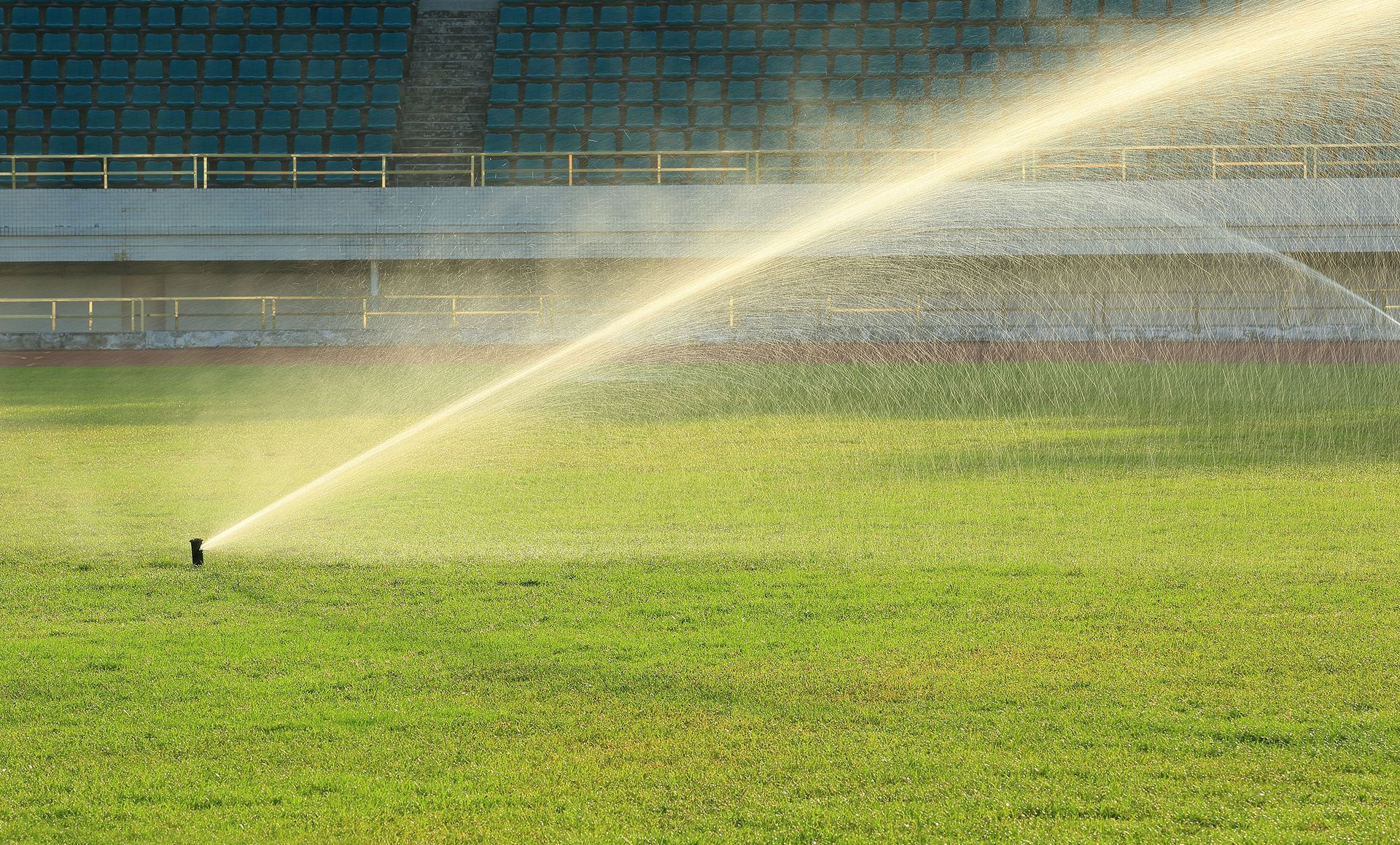 A sprinkler is spraying water on a soccer field.