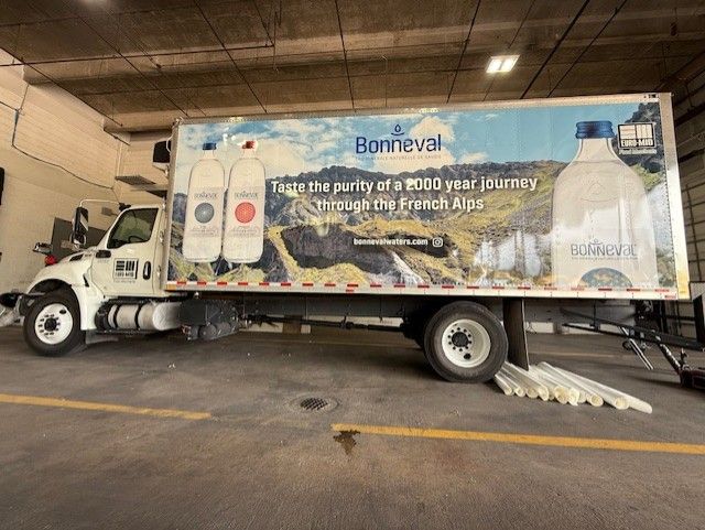 Box truck with Bonneval water advertisement.