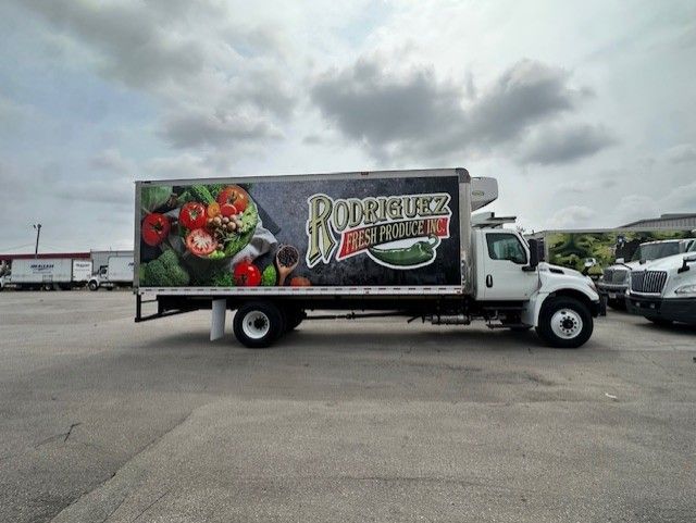 White Rodriguez Fresh Produce truck in a parking lot under a cloudy sky.