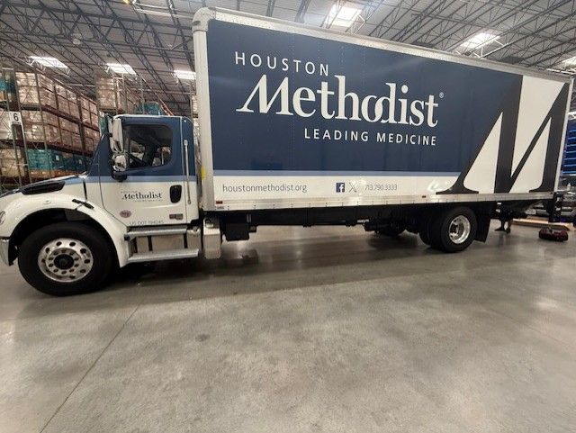 Houston Methodist truck in a warehouse. White and blue with 