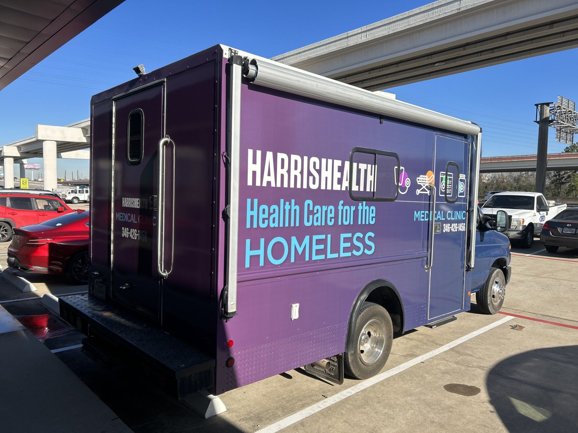 Purple HarrisHealth mobile clinic parked; 