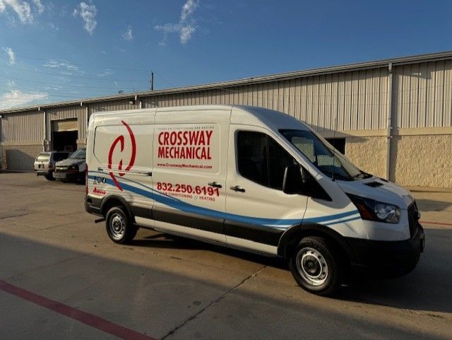 White Crossway Mechanical van parked in front of a building. Blue and red logo with phone number.
