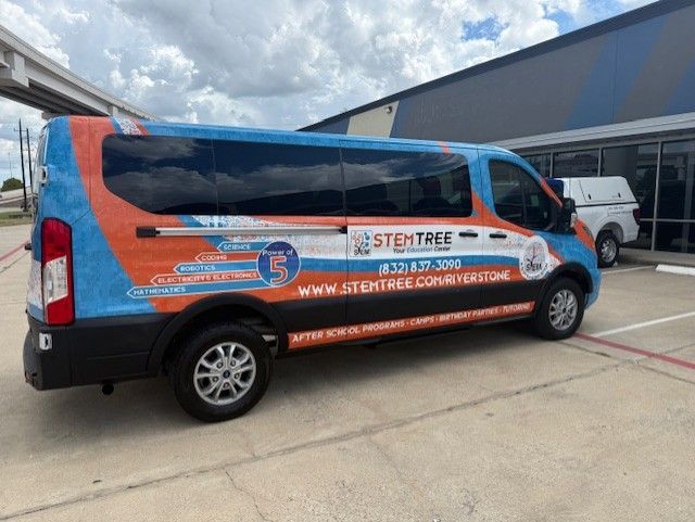 Blue and orange STEMTREE van parked outside a building, with logos and contact information visible.