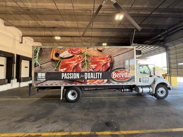 Beretta refrigerated truck with meat advertisement in loading dock.