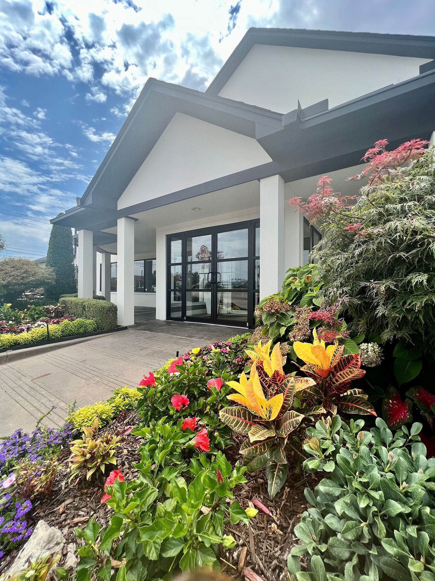 A large white house with a lot of flowers in front of it.