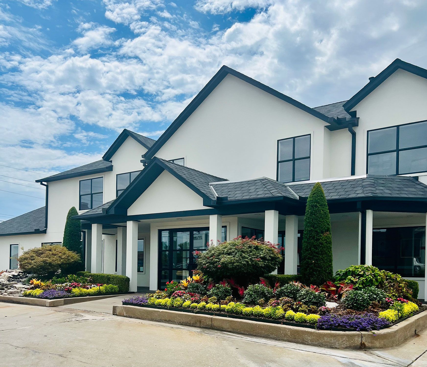 A large white house with a black roof and a lot of windows.