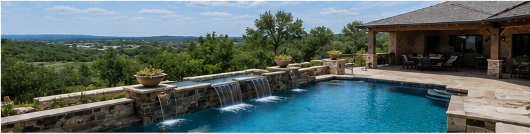 Backyard pool with waterfall, stone patio, and mountain view under a blue sky