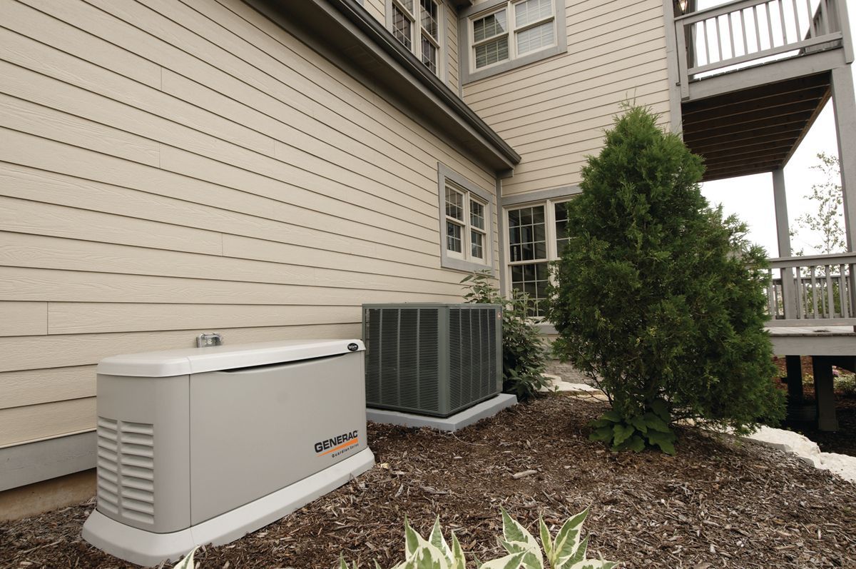 Generator beside a house, next to an air conditioning unit and bushes.