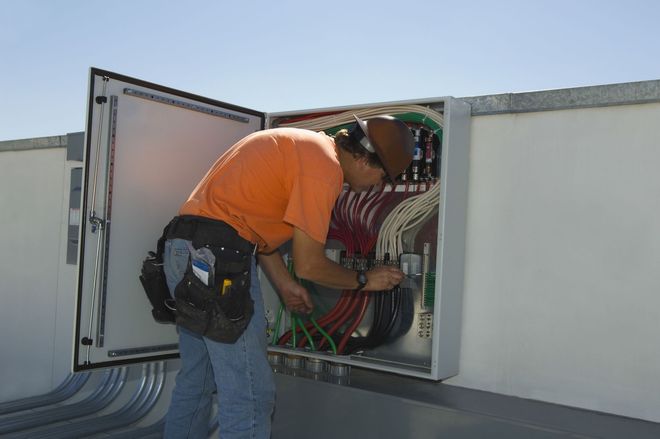 Green and black portable generator with a protective metal frame.