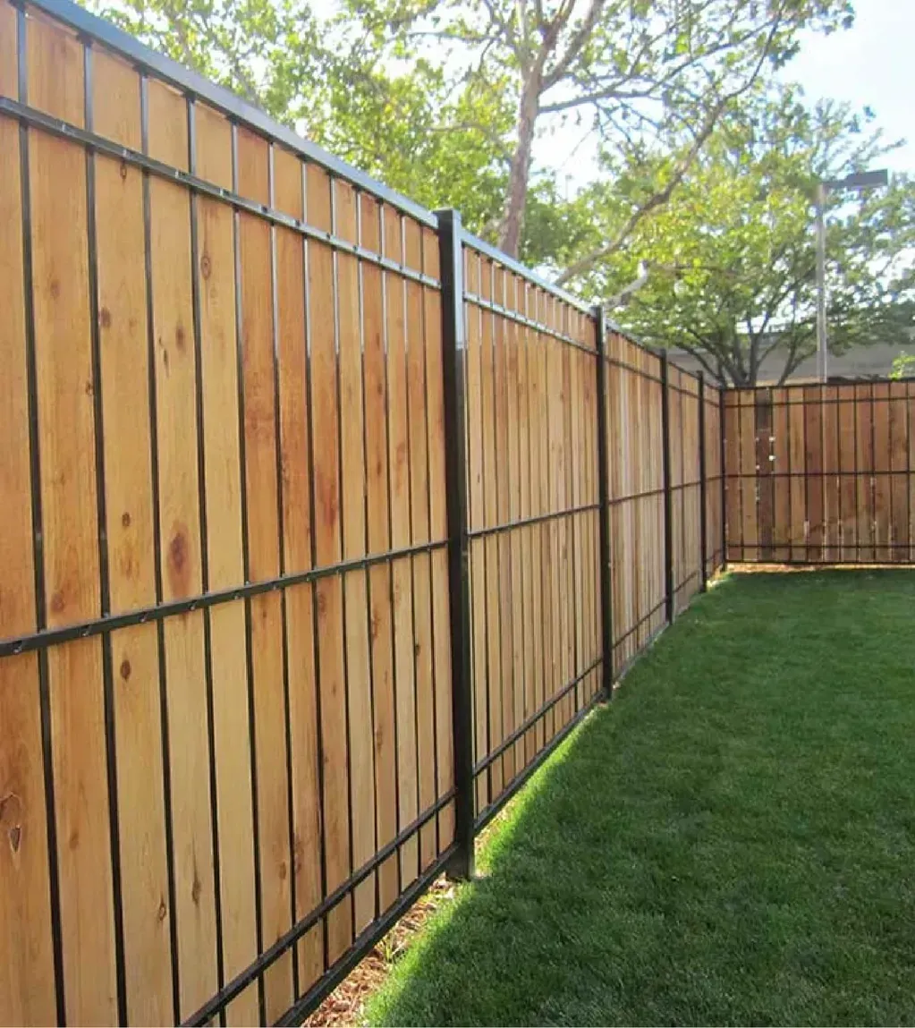 Wooden fence with black metal frame enclosing a grassy yard.