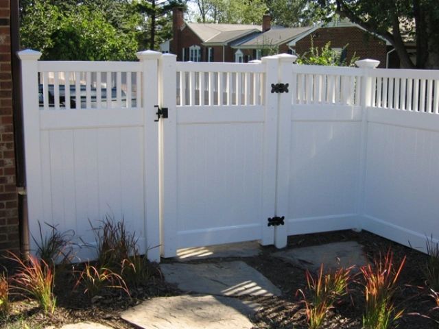 White vinyl fence with gate and black hinges.