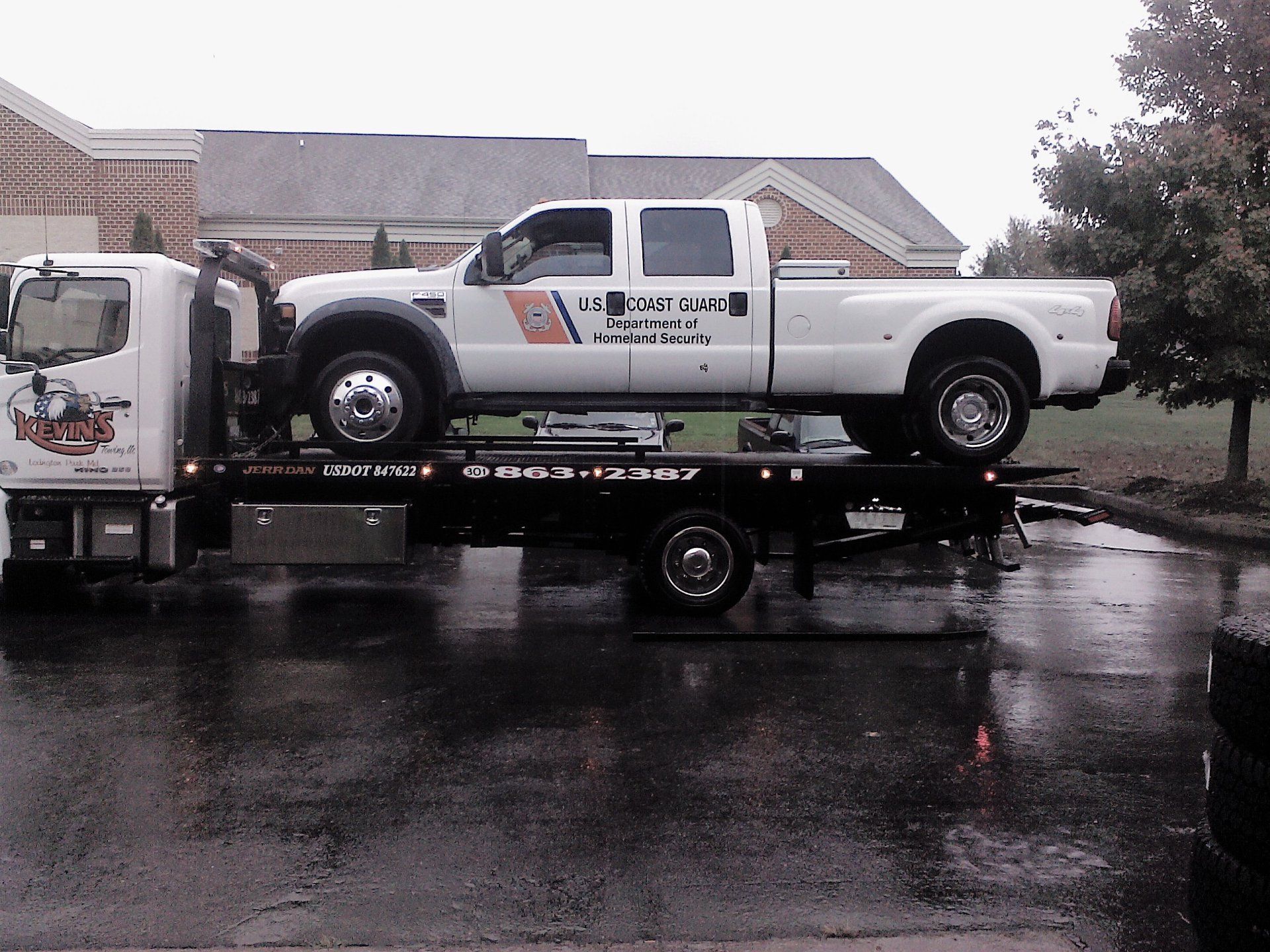 A tow truck with a white truck on top of it
