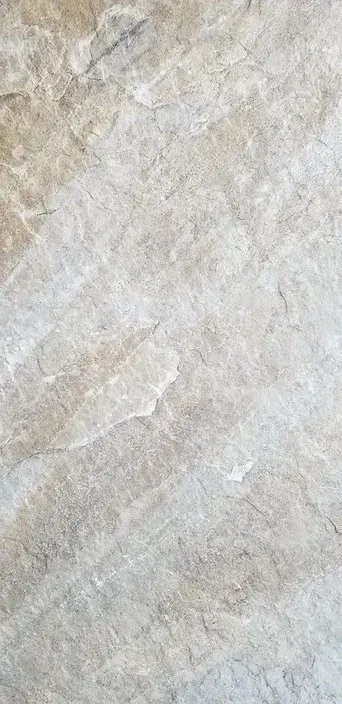 Close-up of a beige-gray stone or marble surface with subtle diagonal veining.