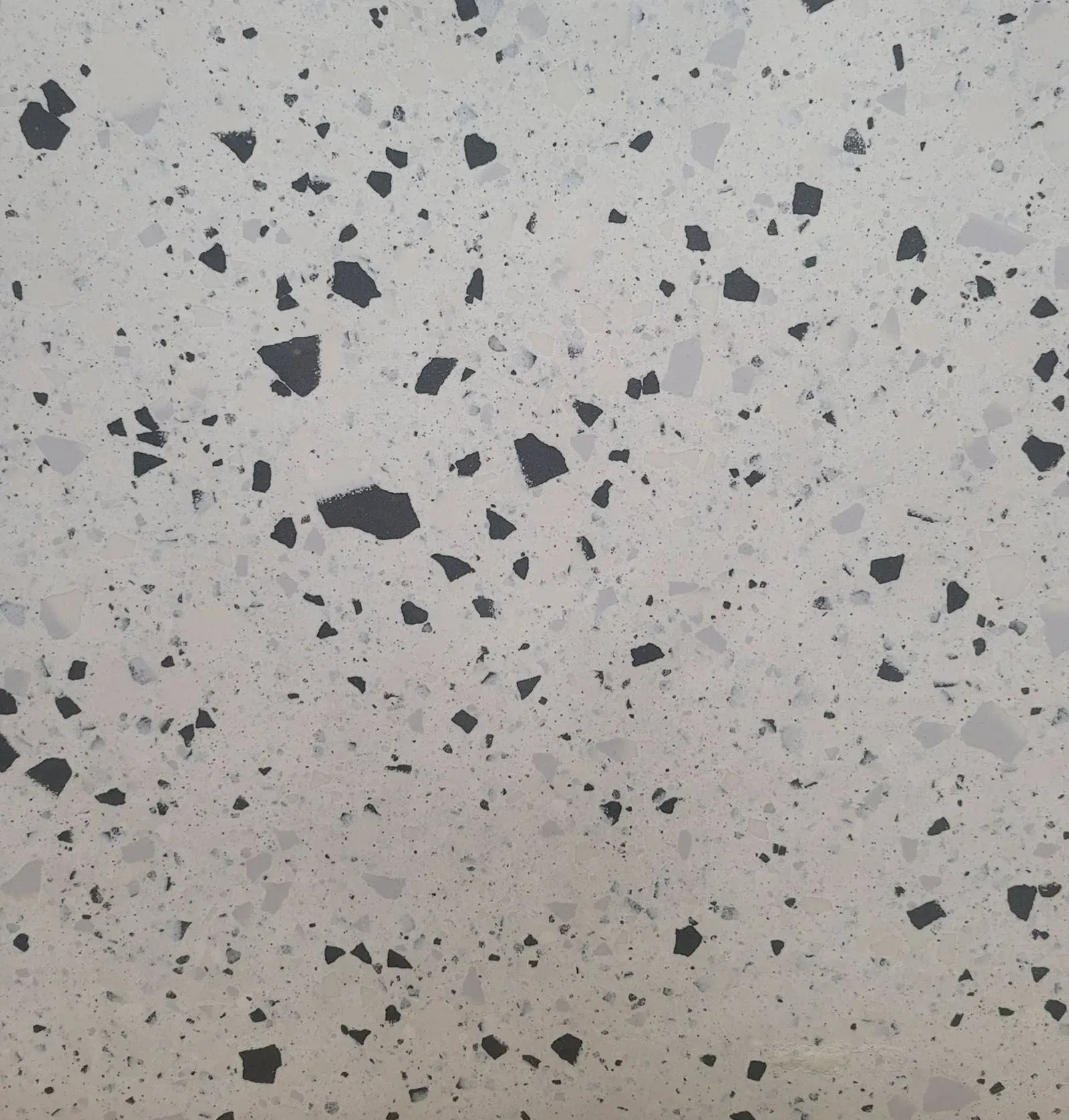 Light gray terrazzo-like surface with scattered dark stone specks