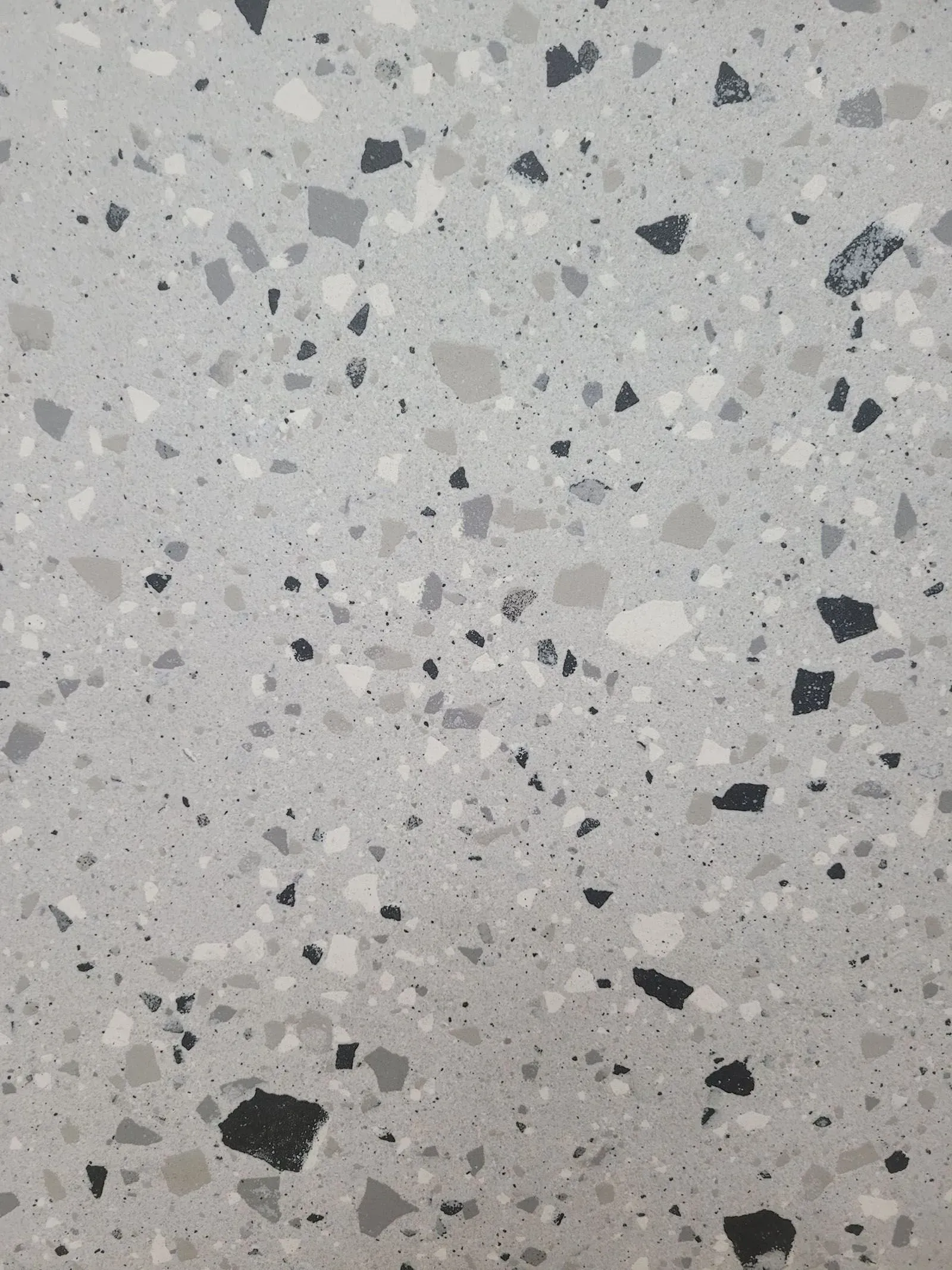 Light gray speckled terrazzo surface with scattered dark flecks